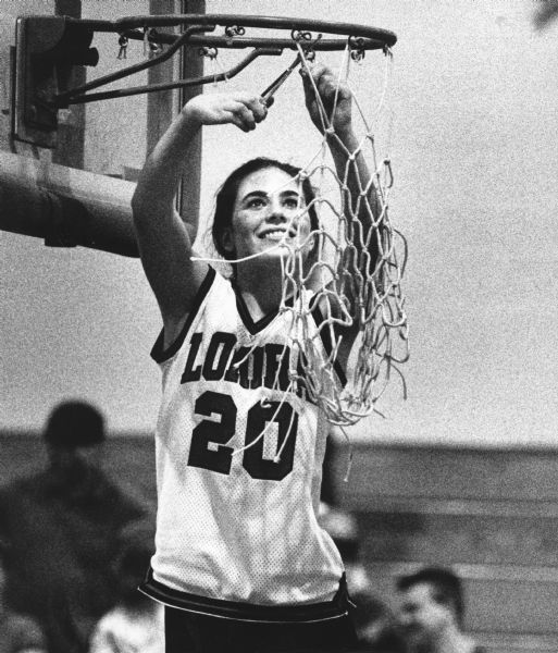 "After the sectional victory, Lomira Lions took turns in snipping off the net at Beaver Dam. Sally Buerger took her turn."