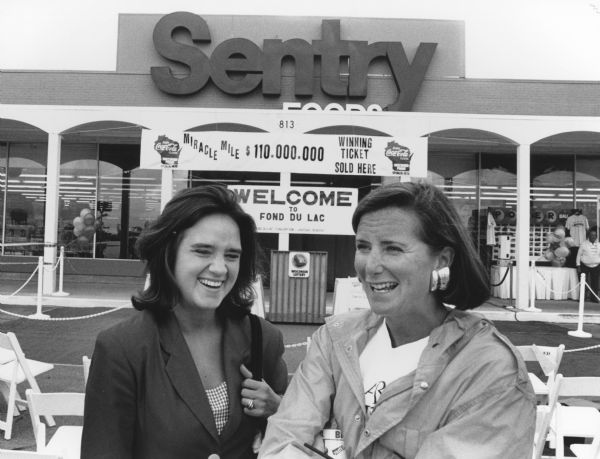 "TV news people stand in front of the Fond du Lac Sentry store where the winning ticket was purchased."