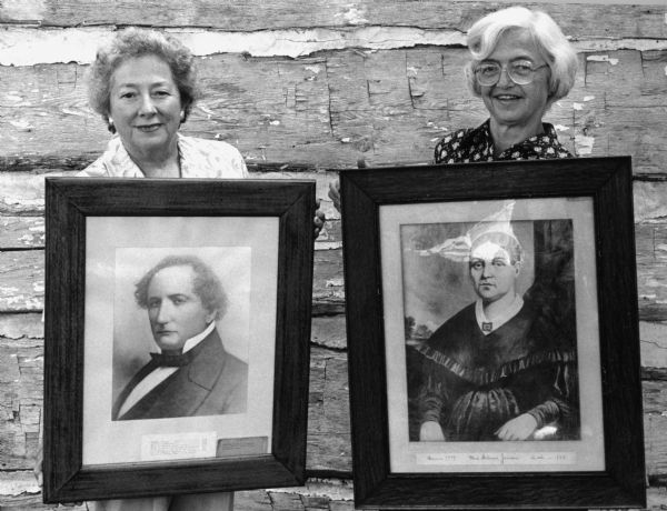"Arlene Beck and Evangeline Koll display portraits of Solomon Juneau and Josette Juneau."