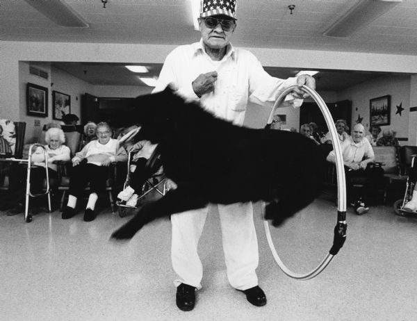 "Ossie Reimer of Lomira with his dog, Rusty, entertains patients at Hope Nursing Home."