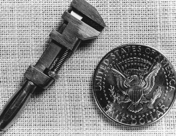 "This tiny miniature wrench, photographed next to a 50-cent piece, is the creation of Arnold Hartmann, the master, from Mayville."