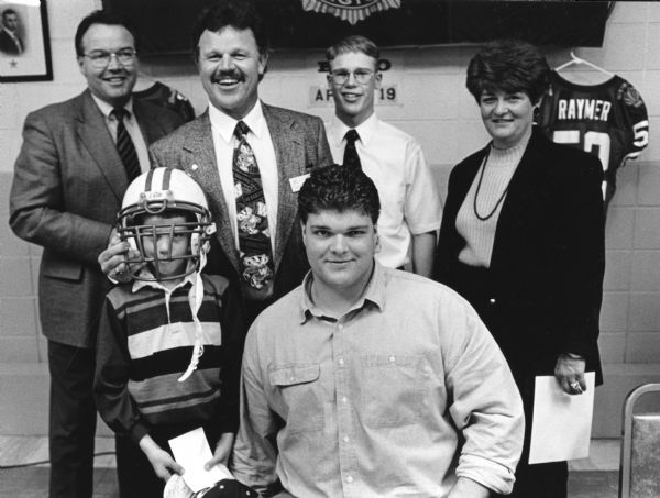 "Chuck Bernhard and his two sons were photographed with University of Wisconsin football player Cory Raymer, and his parents of Fond du Lac.  Cory went on to play for the Washington Redskins."