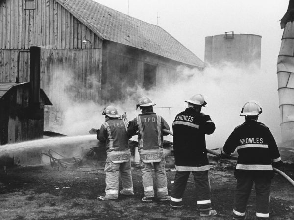 "Theresa and Knowles firemen battle a blaze on the Richard Schwertz farm on Cty WT near Mayville."