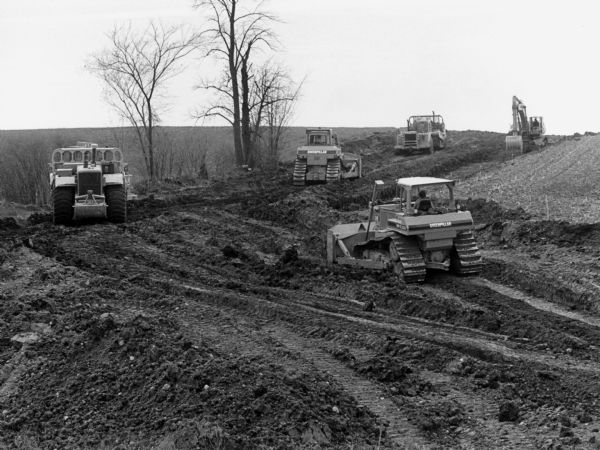 "Road workers grade for the new road near the water tower."