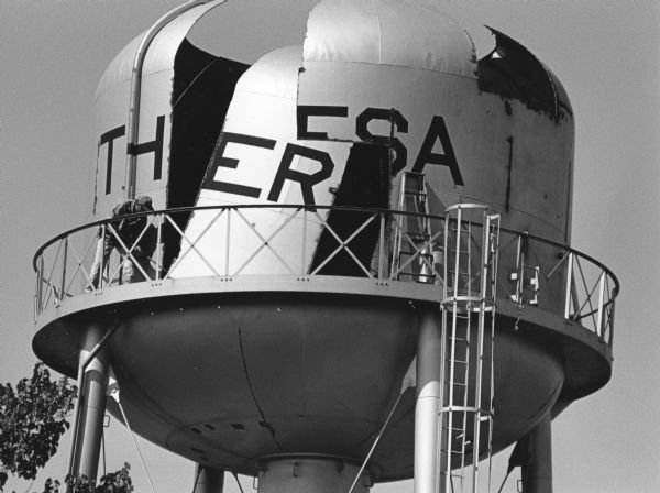 "Theresa's water tank, erected in 1953, is systematically cut up for scrap by Phillips Demolition Co. of Peoria, Illinois."