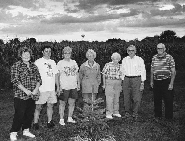 "Assisting in planting this tree in Rivers Edge Park are: Village President Chris Giese, Ron and Janet Wendling, Shirley Widmer, Delores and Gordon Loehrke, and John Bodden."