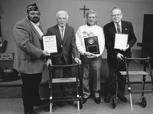 "At the Legion's 79th Birthday Party, World War II veterans were honored. Commander Greg Krueger presents awards to Ralph Widmer, Navy; Bud Ruecker, Army Air Force; and Les Beck, Army."