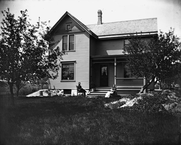 View of Alex and Florentina Krueger sitting in front of their newly built house.