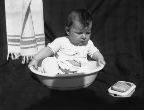 View of Florence Gericke as an infant, sitting in a wash basin.