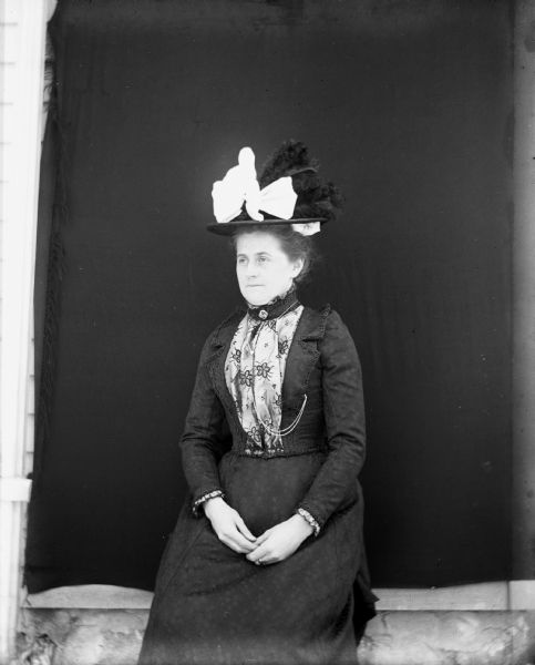 Portrait of Florentina Krueger, sitting and wearing a feathered hat.