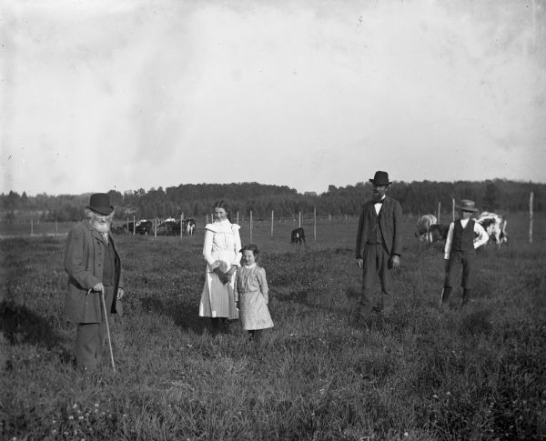 View of William, Lillie, Selma, Albert, and Bennie Krueger standing in the pasture with cows and calves.