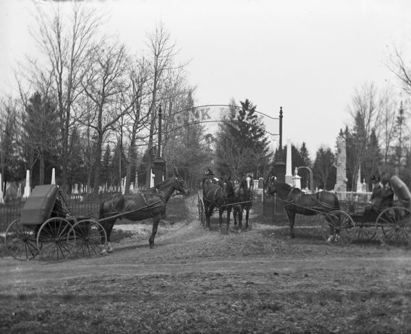 The horses and buggies of William Wills, A. Pautz, and Sarah Krueger are at the gate of Oak Hill Cemetery, founded in 1850.