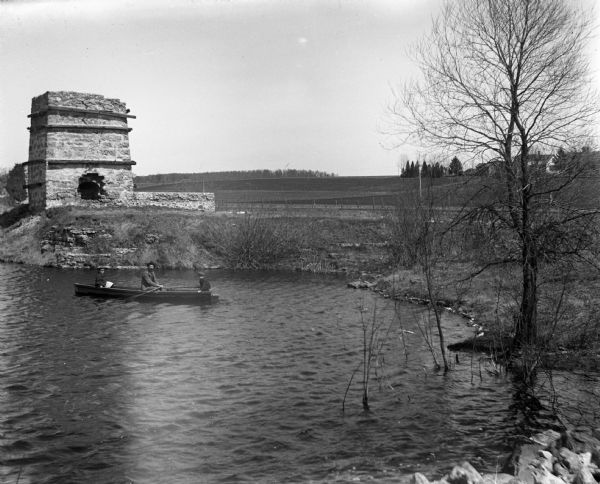 Alexander, Jennie, and Edgar Krueger in a rowboat on the quarry pond.  The remnants of the old kiln stand on the hill above the pond.