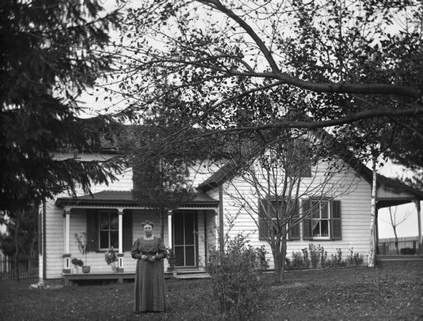 Sarah Krueger standing in front of the home of August Krueger.