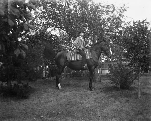 Sam Goetsch sitting on a horse in a fenced-in yard.