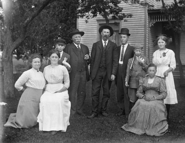 Group portrait of the Krueger and Buening Families in front of the Krueger household. Florentina, Edgar, August, Alexander, Mary and Jennie Krueger with Ed Buening, Mrs. Buening, and their son.