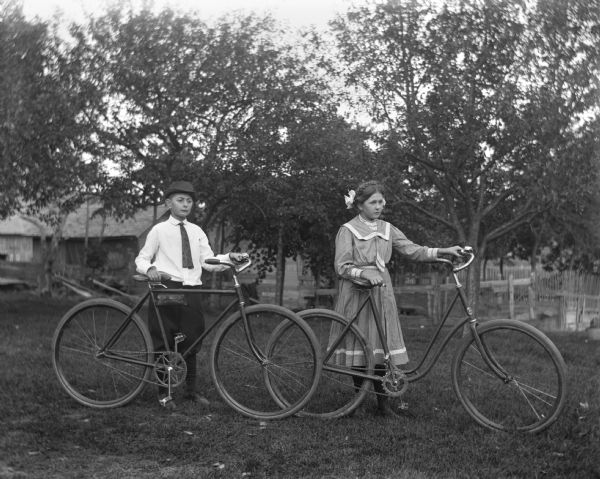 The Krueger twins, Jennie and Edgar, age 11, posing with their bicycles.
