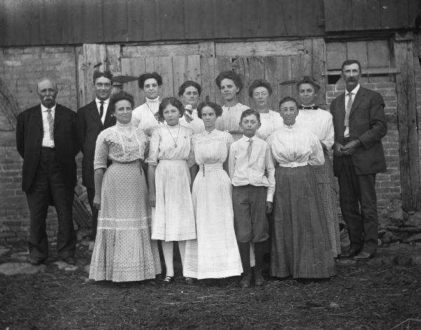 Outdoor group portrait of the Krueger and Hable families in front of the Krueger's barn.