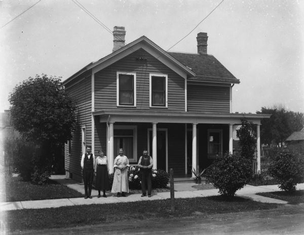 Ernst Bruetzman, Jennie Krueger Bruetzman, and Mr. and Mrs. August Bruetzman in front of the Bruetzman home on 11th street.