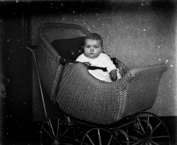 Indoor portrait of Shirley Krueger sitting in a baby carriage.