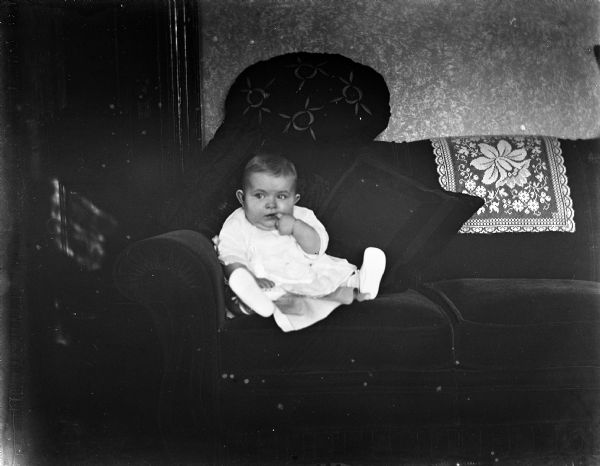 Eight-month-old Shirley Krueger propped up on the sofa with pillows.