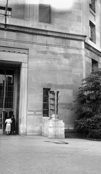View of the entrance of the Federal Bureau of Investigation building. Three women are entering the building.