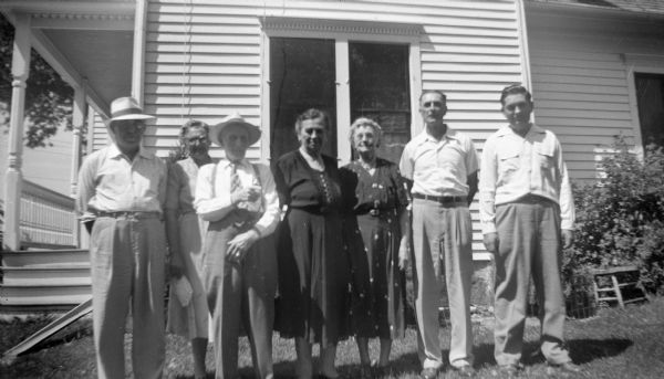 Group portrait of Florentina, Edgar, and Robert Krueger, with two other couples, standing in front of a home. Florentina, Edgar, and Robert stand on the far right.