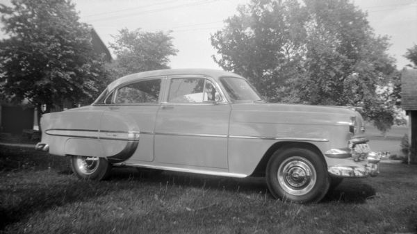 Right side view of an Chevy automobile parked in the grass at the Krueger farm.