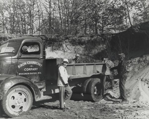 Jean Nash, cranberry grower, posed next to a truck for the Biron Cranberry Company.