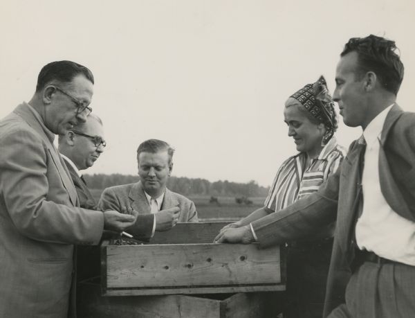 From left to right: W.A. Riordan, John Buck, Leo Sorenson, Jean Nash and Del Hammond. Miss Nash, the owner of the cranberry marsh, escorts representatives from Kroger Grocery Company to have a look at some of the freshly harvested cranberries. The photograph was taken during "Cranboree," a cranberry festival held in nearby Wisconsin Rapids.