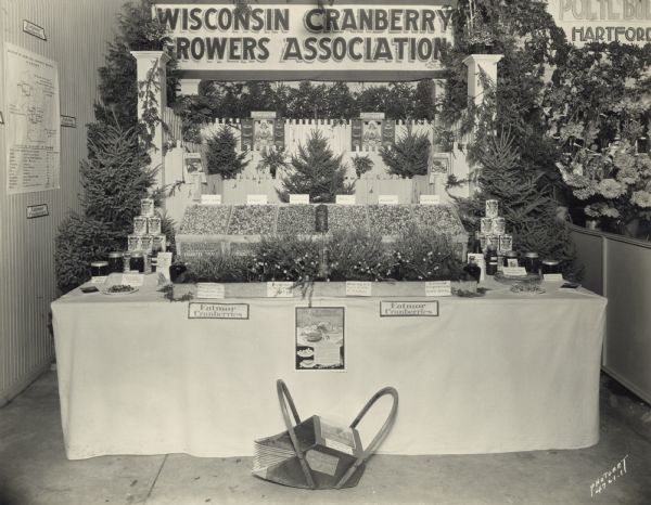 Agricultural exhibit designed by the Wisconsin State Cranberry Growers Association and Eatmor Cranberries. The exhibit shows various types and stages of cranberry plants, harvested cranberries, cranberry products, and recipes that use cranberries.