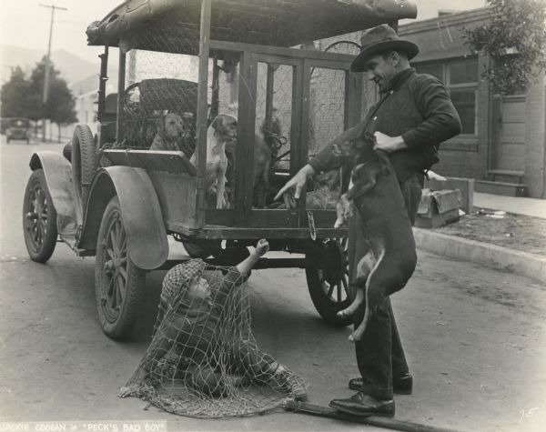 Henry Peck (played by Jackie Coogan) has been caught in a net by the dog catcher in this scene still from the silent film "Peck's Bad Boy" (First National 1921).