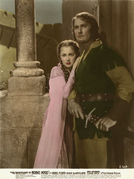Olivia de Havilland (playing Maid Marian) and Errol Flynn (Robin Hood) in a hand-colored publicity still from director Michael Curtiz's film "The Adventures of Robin Hood" (First National 1938).