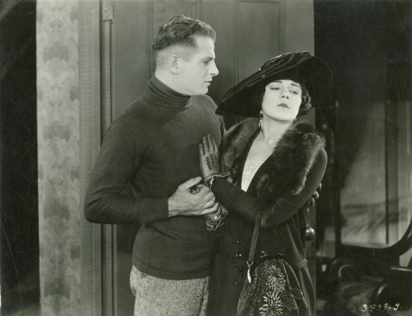 The boxer Pat Glendon, Jr. (played by Reginald Denny) grasps the hand of socialite Maude Sangster (Mabel Julienne Scott) in a scene still from "The Abysmal Brute" (Universal 1923).