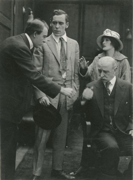 The actor Vester Pegg is reaching to shake the hand of Charles Lee (playing Mr. Pepper). Pepper's son and daughter watch (Jack Conway and Irene Hunt) in this scene still from "Added Fuel" (Reliance 1915).