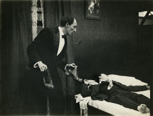 The butler (played by Philip Gastrock) finds, or plants, muddy shoes next to a sleeping man (Vester Pegg).