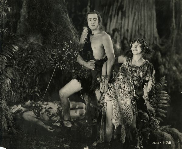A caveman (played by Elliott Dexter) has defeated a rival and thus wins the interest of the Mischevous One, a young cavewoman played by Julia Faye in this Cecil B. DeMille silent film from 1923 set partially in prehistoric times. Both are dressed in animal furs.