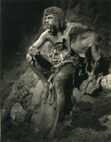 Milton Sills as a caveman dressed in fur and armed with a stone club in a prehistoric forest in Cecil B. De Mill's silent film production "Adam's Rib" (Famous Players-Lasky 1923).