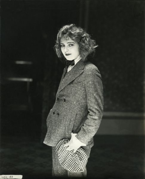 Phyllis Blake (played by Corinne Griffith) dressed as a man in a salt-and-pepper suit and bow tie.