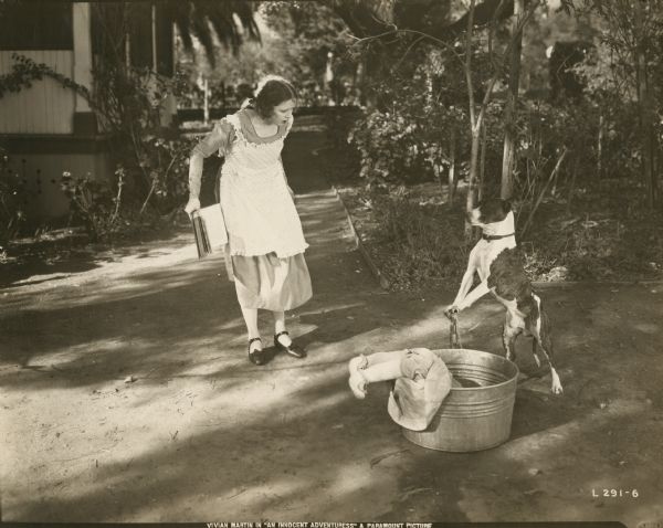 Vivian Martin (playing Lindy) confronts Togo the dog whom she has caught washing a toddler (or perhaps a doll) in a washtub in "An Innocent Adventuress" (Lasky 1919).