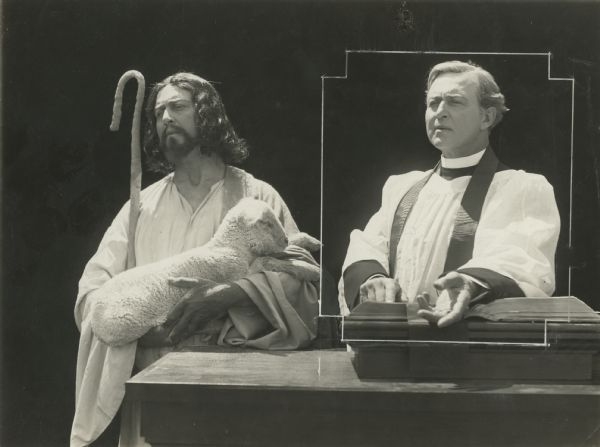 The Reverend Eric Norton (played by Hobart Bosworth) stands preaching next to Jesus (also played by Hobart Bosworth) who has a lamb in his arms. This elaborate double exposure was made as a publicity still for the silent film "The Scarlet Sin" (Universal 1915).