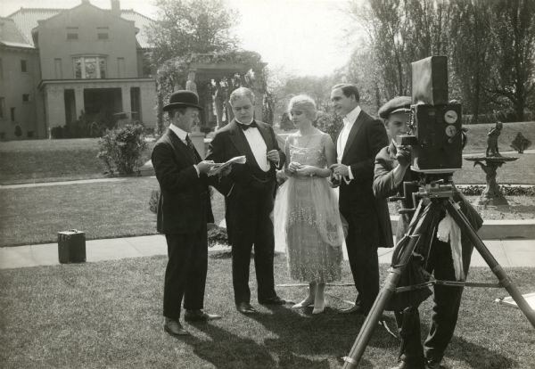 Original caption:
"Director Paul Scardon, discussing the script of a new Blue Ribbon feature with the players in the cast. Reading from left to right; Paul Scardon, Franklyn Hanna a prominent support, Corinne Griffith one of the leads and Earle Williams, the star."
