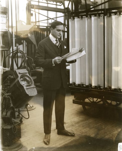 Earle Williams, Vitagraph star, studies a script in front of a bank of Cooper-Hewitt lights.