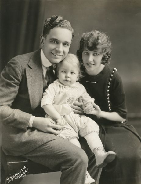 Original caption: "Here's the real boss of the Santley Family.
Joseph Santley and Ivy Sawyer, stars of the 'Music Box Revue', may have to obey the orders of a stage manager while appearing at the Music Box Theatre in New York, but the real boss of the Santley menage is little Joseph, Jr., their three-year-old son. When the Santleys are not occupying their dressing-rooms at the theatre, they can be found at their beautiful home in Great Neck, Long Island, where Joe, Jr. is the managing director."