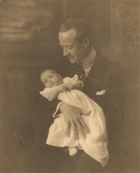 Stage and silent film actor H.B. Warner holding his daughter Joan Warner in his arms. The child's mother was actress Rita Stanwood.