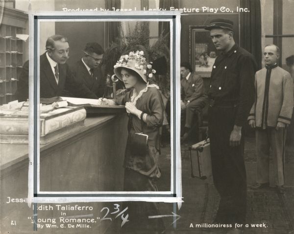 Nellie Nolan (played by Edith Taliaferro) signs the register of an expensive resort hotel under the assumed name Ethel Van Dusen in a scene still from "Young Romance" (Lasky 1915).