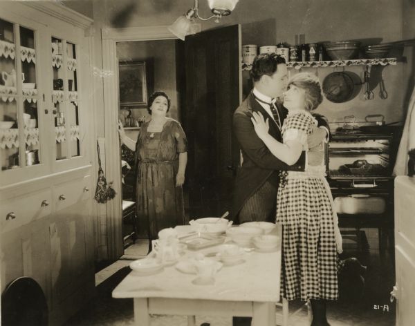 Mrs. Esther Meyers (played by Vera Gordon) discovers her son Robert Meyers (Harry Benham) and Aida (Belle Bennett) embracing in the kitchen.