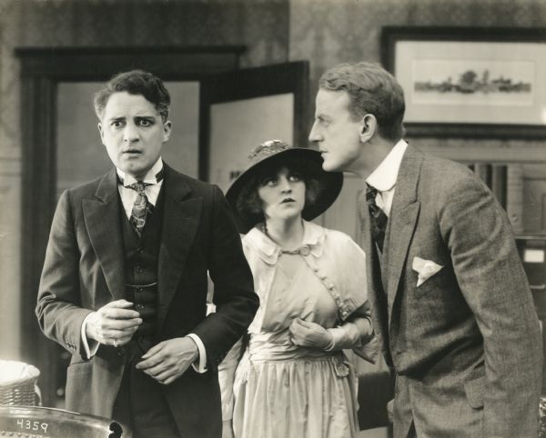 Jack Thomas (played by Bryant Washburn) is falsely accused by Philip Cole (Patrick Calhoun) as his young ward Elsa Thomas (Marguerite Clayton) watches in a scene still from the 1916 Essanay production "Worth While."