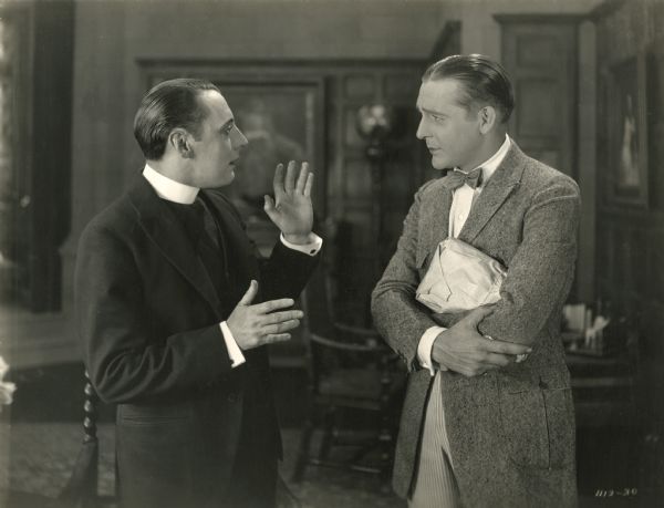 The Reverend David Burroughs (played by Leslie Casey) has a serious discussion with William Burroughs (Wallace Reid) in a scene still from "The World's Champion" (1922).