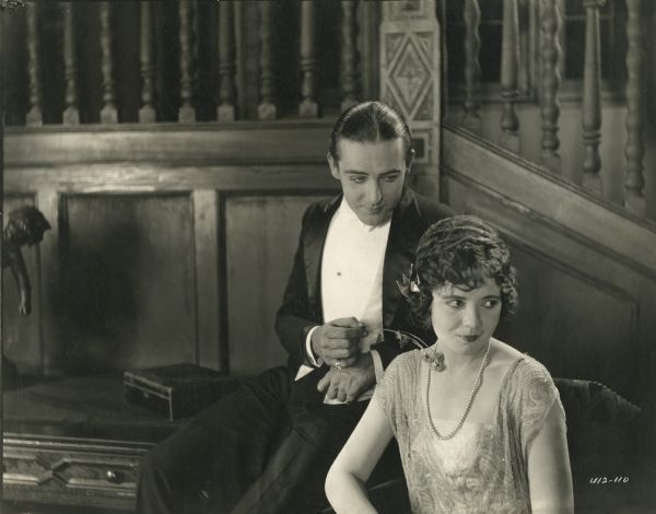 William Burroughs (played by Wallace Reid in formal evening wear and well-oiled hair) uses a flower to toy with Lady Elizabeth Galton (Lois Wilson) in a scene still from "The World's Champion" (1922).